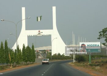 NIGERIA - DECEMBER 11:  Cars drive past the city gate in Abuja, Nigeria, Monday, December 11, 2006. OPEC, the producer of 40 percent of the world's oil, convenes this week in Abuja, Nigeria, its first conference in Africa's largest oil-producing nation since 1972.  (Photo by Suzanne Plunkett/Bloomberg via Getty Images)