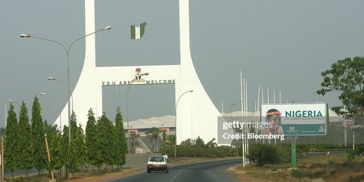NIGERIA - DECEMBER 11:  Cars drive past the city gate in Abuja, Nigeria, Monday, December 11, 2006. OPEC, the producer of 40 percent of the world's oil, convenes this week in Abuja, Nigeria, its first conference in Africa's largest oil-producing nation since 1972.  (Photo by Suzanne Plunkett/Bloomberg via Getty Images)