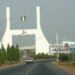 NIGERIA - DECEMBER 11:  Cars drive past the city gate in Abuja, Nigeria, Monday, December 11, 2006. OPEC, the producer of 40 percent of the world's oil, convenes this week in Abuja, Nigeria, its first conference in Africa's largest oil-producing nation since 1972.  (Photo by Suzanne Plunkett/Bloomberg via Getty Images)